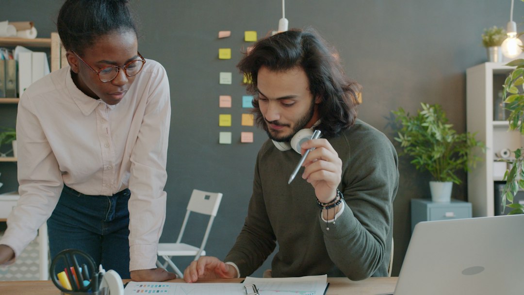 Two colleagues collaborating at a desk in an office